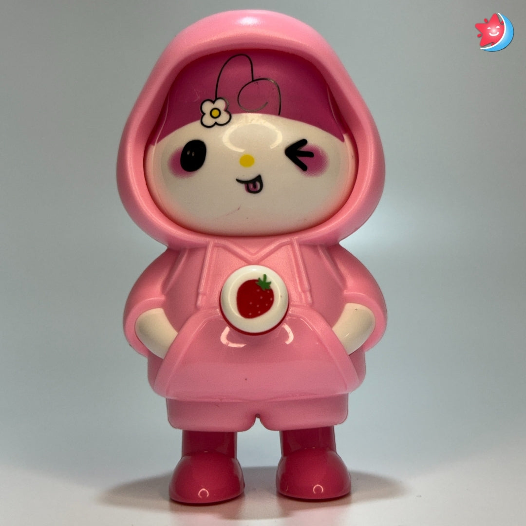 Toy figure in a pink outfit with a hood on a gray background
